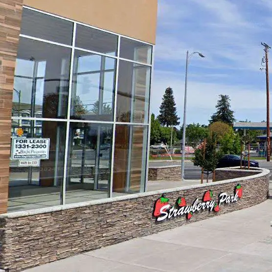 Store front for lease and sighn that says "Strawberry Park".